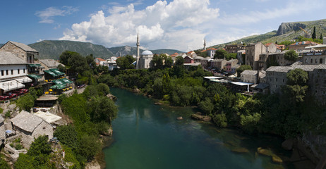 Fototapeta premium Bosnia: lo skyline di Mostar, la città vecchia sul fiume Narenta, con vista dei palazzi colorati del vecchio bazar Kujundziluk, il quartiere musulmano, e della moschea Koshi Mehmed Pasha