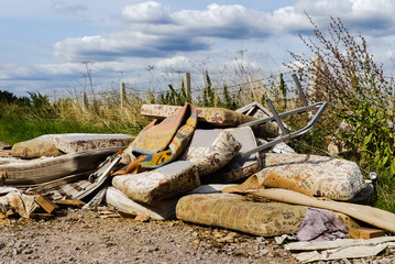 Blight of illegally dumped household rubbish left in a little used country lane. Environmental hazard, with furniture. mattresses and carpets. Fly tipped detritus. Oxfordshire. - 220286858