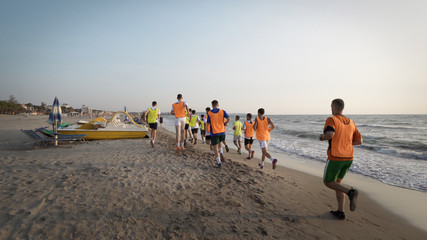 Durres, Albania - circa August, 2017: Football sport team is engaged in jogging training at sea at...
