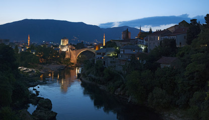 Obraz premium Mostar: vista notturna dello Stari Most (Ponte Vecchio), ponte ottomano del XVI secolo, simbolo della città, distrutto il 9 novembre 1993 dalle forze militari croate durante la guerra croato-bosniaca