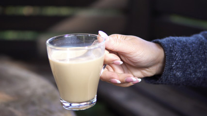 Beautiful young woman drinking coffee sitting outdoors