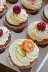 Vanilla cupcakes with fruits on top.