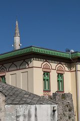 Bosnia: lo skyline di Mostar, la città vecchia sul fiume Narenta, con un palazzo esempio dell'architettura austro-ungarica costruito durante il periodo della dominazione austro-ungarica