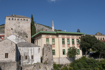 Fototapeta na wymiar Bosnia: lo skyline di Mostar, la città vecchia sul fiume Narenta, con un palazzo esempio dell'architettura austro-ungarica costruito durante il periodo della dominazione austro-ungarica