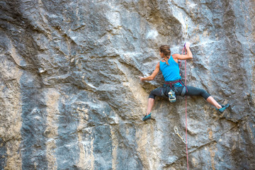 The girl climbs the rock.