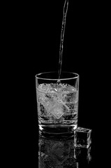 Carbonated water, which is poured into a glass with ice cubes.