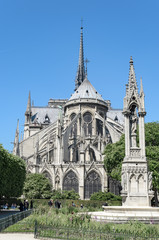 Fototapeta na wymiar View of the East-end of the Notre-Dame de Paris cathedral in the morning with the fountain of the Virgin in the foreground, vertical