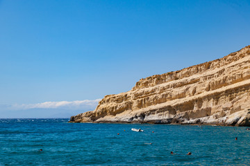 Fototapeta na wymiar Cliff in Matala beach with caves on the rocks that were used as a roman cemetery. Crete, Greece.
