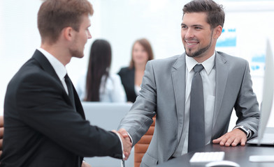 Fototapeta premium handshake of business partners sitting at a Desk.