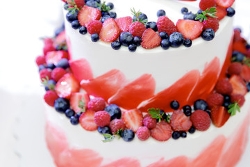 Wedding cake red velvet with fresh berries strawberries and blueberries.