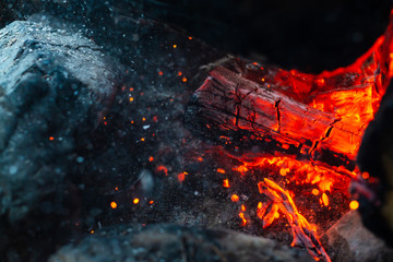 Smoldered logs burned in vivid fire close up. Atmospheric background with flame of campfire....