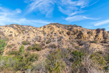 Rocky hillsides in California desert mountains on hot summer afternoon with room for text in sky