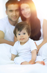 Obraz premium Happy couple and son sitting in bed
