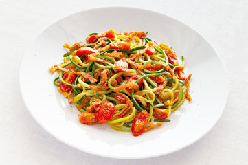 zucchini pasta with tomatoes, bacon, onion, and chili sprinkled with pepper