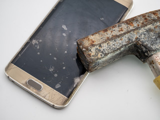 close-up of damaged smartphone display with hammer