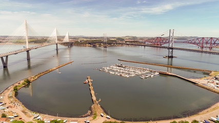 Aerial image looking over the marina at South Queensferry to the Forth road and rail bridge and new Queensferry Crossing.