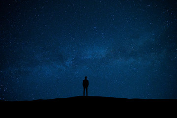The man standing on the starry sky background © Artem