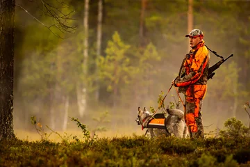 Fotobehang Jacht Jager en jachthonden jagen in de wildernis