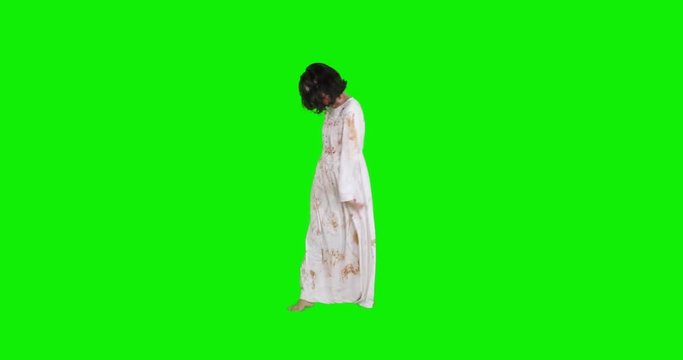 Full length of scary zombie woman with wounded face, walking in the studio with green screen background. Shot in 4k resolution