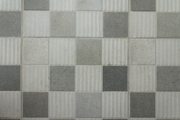 Grey floor tiles in dismal dark black and white shot.  Light tiles.