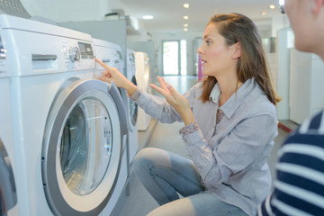 Couple looking at washing machine in store