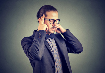 Concentrating businessman holding fingers on temples