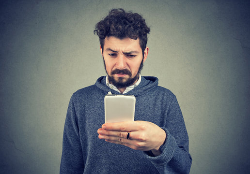Angry annoyed man using smartphone