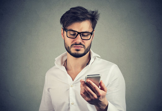 Angry disgusted man using smartphone