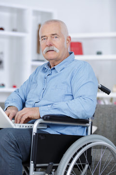 disabled man in wheelchair typing on laptop