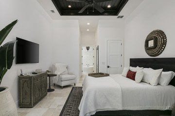 modern white master bedroom with tiled floors and black wooden ceiling detailing