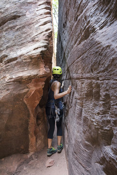 Female rock climber walking in between rock walls