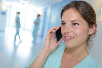 female surgeon using cell phone in hospital