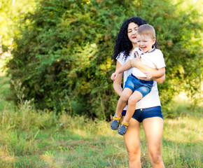Fototapeta premium Portrait of happy mother and son smiling outdoors