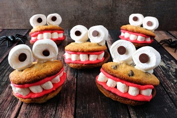 Group of fun Halloween monster cookies on a rustic dark wood background