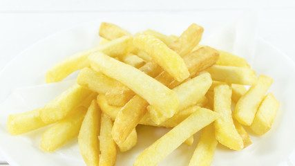 French Fries in a white dish on a table white background, Close up, with copy space for your text..