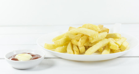 French Fries and tomato sauce in a white dish on a wood floor table,Front view Copy space.