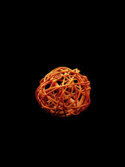 Orange braided ball on black background