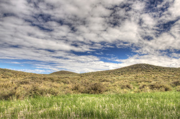 Meadow and hill under the cloudy sky