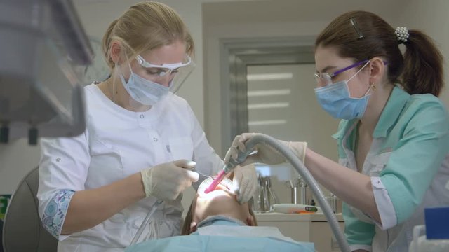 Dentist Is Treating Patient In Modern Dental Office