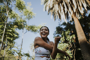 Happy woman stretching in the park