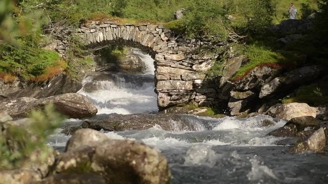 Scenic Scandinavian River and the Stone Bridge in Slow Motion