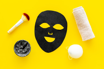 Black facial mask. Black head remover mask. Mask with clay on yellow background top view