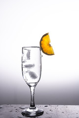 Glass of liquid with splash made dropping a slice of orange