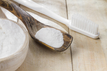 baking soda in bowl on wooden table, close up