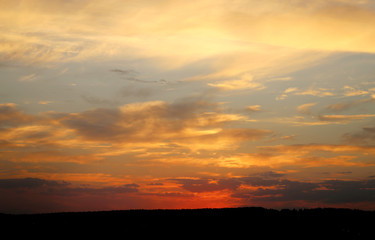 Beautiful photo of a bright sunset with clouds over a field