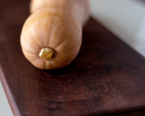 butternut squash pumpkin vegetable on a cutting board with space on the side ideal for food recipes...