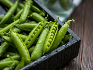 ripe green peas on a wooden background 