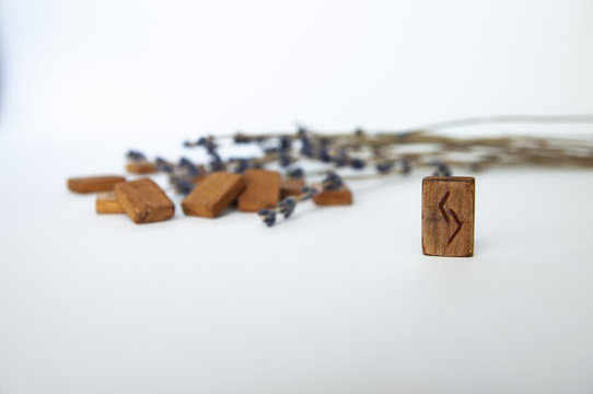 Jera. Scandinavian runes. Wooden runes on a table on a white background.