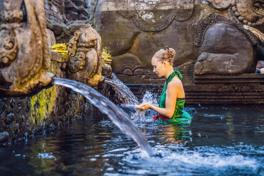 Woman in holy spring water temple in bali. The temple compound consists of a petirtaan or bathing structure, famous for its holy spring water