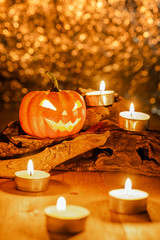 Obraz na płótnie Canvas halloween pumpkin decorate with candles on wooden timber, beautiful bokeh background